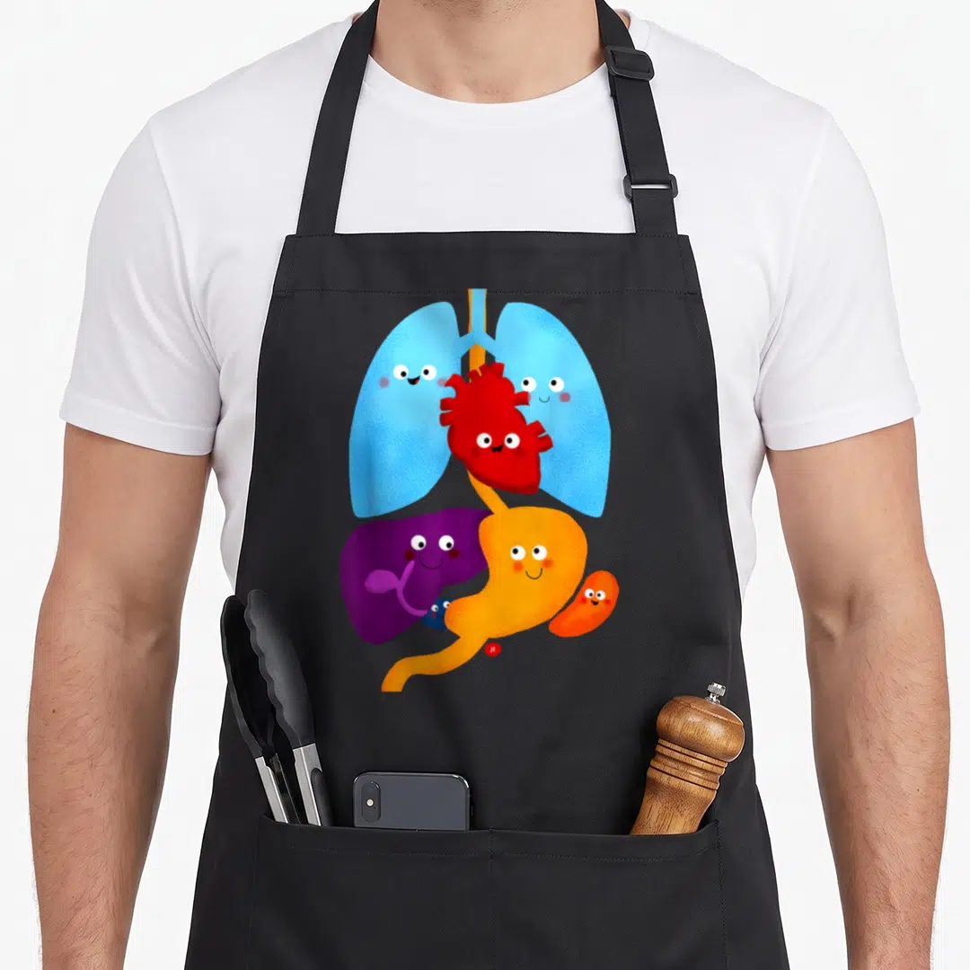 Jen anatomy apron - Smiling cartoon lungs, heart, liver, stomach, and kidney stacked vertically in blue, red, purple — shown on a black cotton canvas apron against a white background