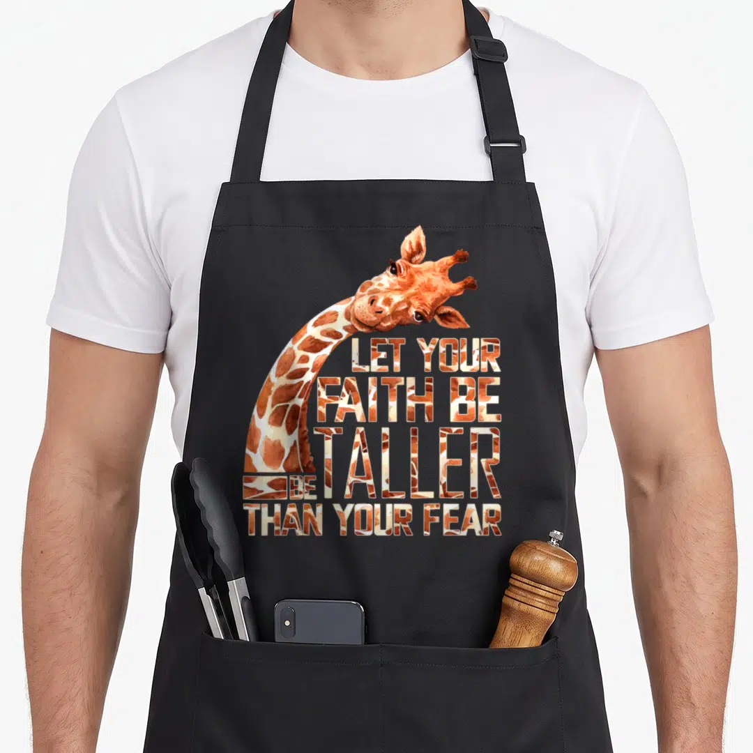 Faith giraffe apron - Watercolor giraffe neck curving around four lines of text filled with hide pattern — shown on a black cotton canvas apron against a white background