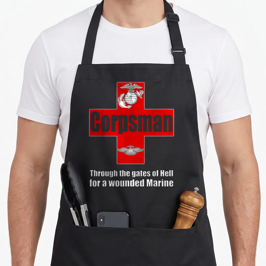 Fmf eagles grill apron - Red cross with grey Corpsman text, two emblems, and white motto on grey background — shown on a black cotton canvas apron against a white background