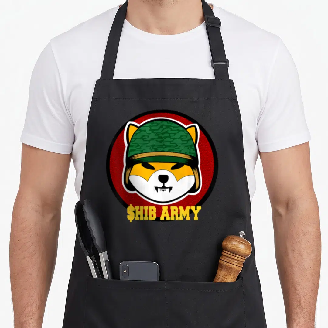 Shib investing apron - $HIB ARMY text under a shiba inu head wearing a green camo helmet inside a red circle — shown on a black cotton canvas apron against a white background