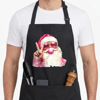 Blowing santa claus apron - Watercolor Santa with pink sunglasses blowing a bubble and making a peace sign — shown on a black cotton canvas apron against a white background