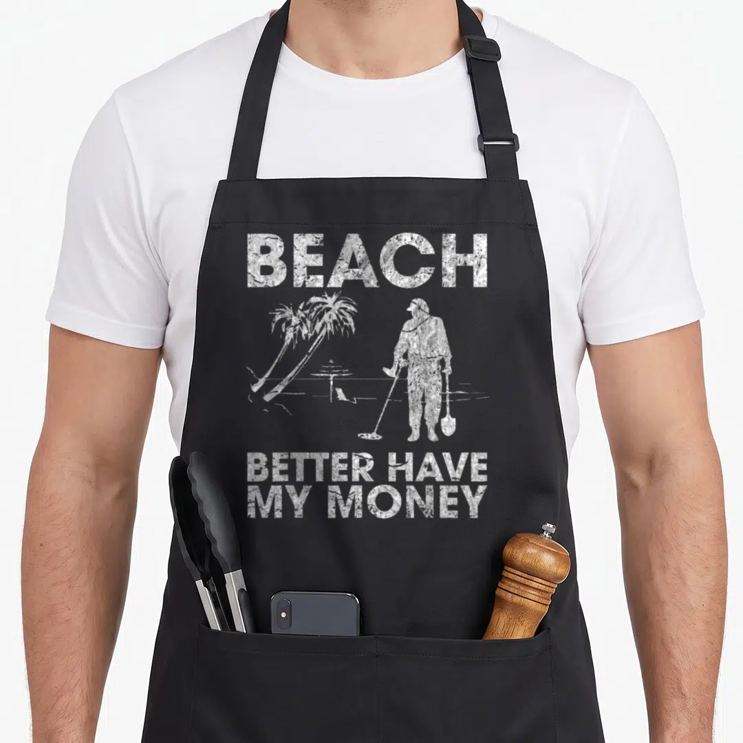 Better money apron - Grey background with white foil-textured text reading Beach Better Have My Money above a golfer — shown on a black cotton canvas apron against a white background