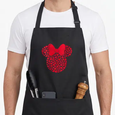 Vintage filled mouse icon apron - Red mouse head silhouette formed by small hearts with a large bow between the ears — shown on a black cotton canvas apron against a white background