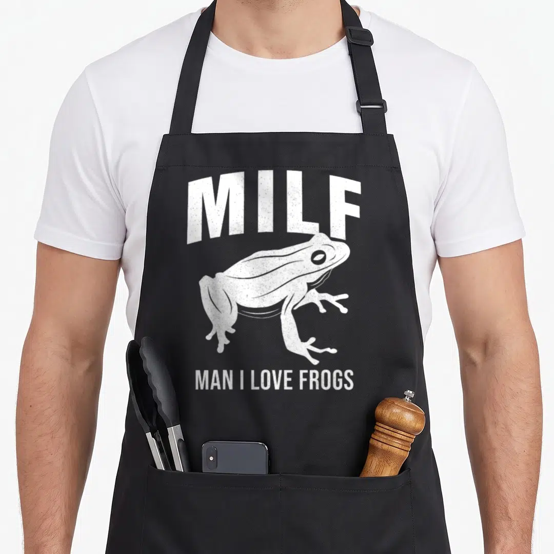 Vintage milf frog aprons - White distressed frog graphic with arched MILF text and Man I Love Frogs caption on black — shown on a black cotton canvas apron against a white background