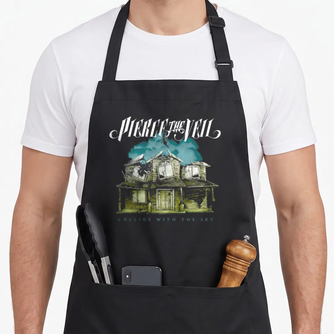 Pierce sky apron - Figure standing on blue clouds above a dilapidated two-story house with distressed white and brown — shown on a black cotton canvas apron against a white background