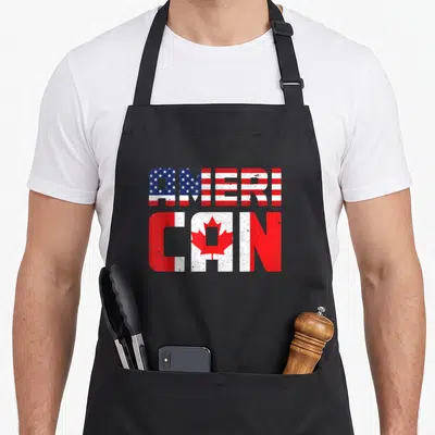 Pride canada american flag apron - Stacked AMERI and CAN text filled with US and Canadian flag patterns in distressed — shown on a black cotton canvas apron against a white background