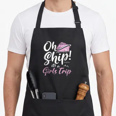 Ship trips apron - Pink cartoon cruise ship and white text reading Oh Ship Its a Girls Trip — shown on a black cotton canvas apron against a white background