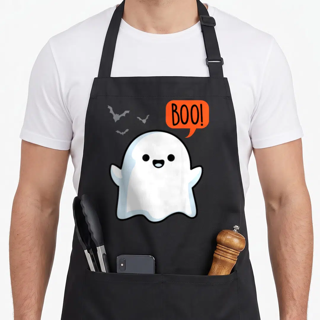 Boo spooky halloween apron - White cartoon ghost with orange speech bubble and three grey bats — shown on a black cotton canvas apron against a white background