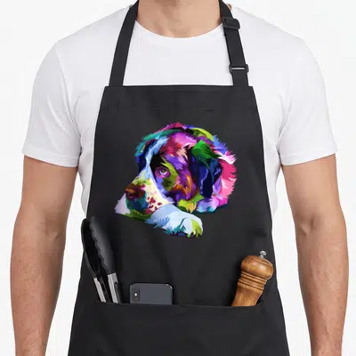 Saint bernard dog apron - Multicolored cartoon Saint Bernard head and paws in blue, green, purple, pink, yellow, and red — shown on a black cotton canvas apron against a white background