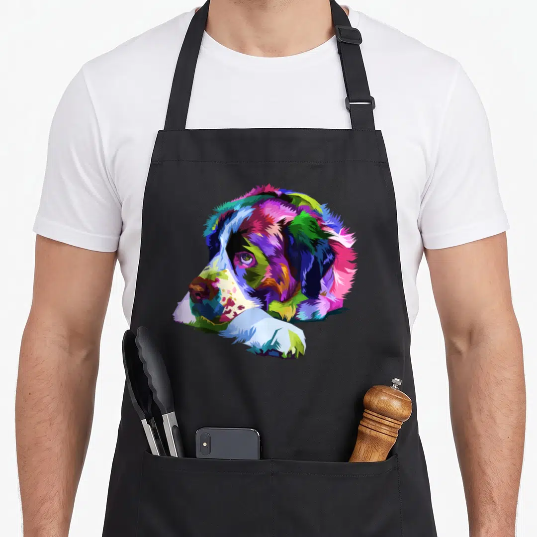 Saint bernard dog apron - Multicolored cartoon Saint Bernard head and paws in blue, green, purple, pink, yellow, and red — shown on a black cotton canvas apron against a white background