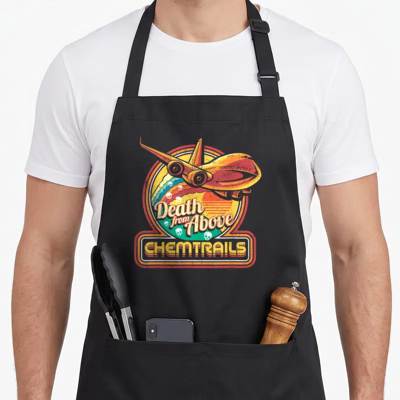 Conspiracy skull apron - Retro airplane and skull graphic with Death from Above and CHEMTRAILS text in orange and green — shown on a black cotton canvas apron against a white background