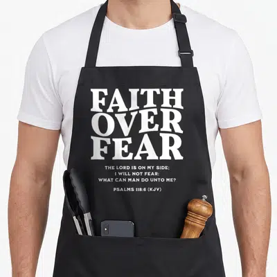 Retro fear faith aprons - White stacked typography reading Faith Over Fear and Psalms 118:6 on black fabric — shown on a black cotton canvas apron against a white background