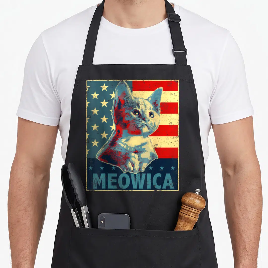 Cat patriotic 4th of july apron - Retro cat portrait over red blue yellow stripes with MEOWICA text at bottom — shown on a black cotton canvas apron against a white background