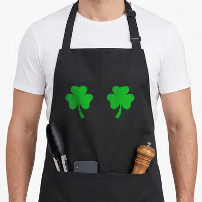 Shamrock irish aprons - Two green cartoon shamrocks side-by-side on grey background — shown on a black cotton canvas apron against a white background