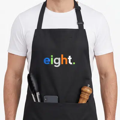 8th eight birthday apron - The word eight spelled in blue, green, grey, orange, and white lowercase letters — shown on a black cotton canvas apron against a white background