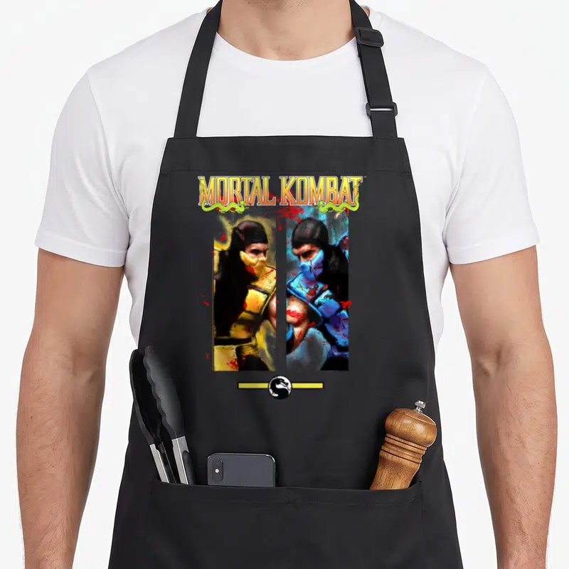 Scorpion video game apron - Two fighters in yellow and blue facing off with red blood splatters under Mortal Kombat text — shown on a black cotton canvas apron against a white background