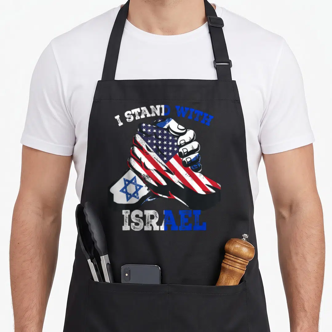 Support jewish aprons - I STAND WITH ISRAEL text over two clasped hands with US and Israeli flag patterns — shown on a black cotton canvas apron against a white background