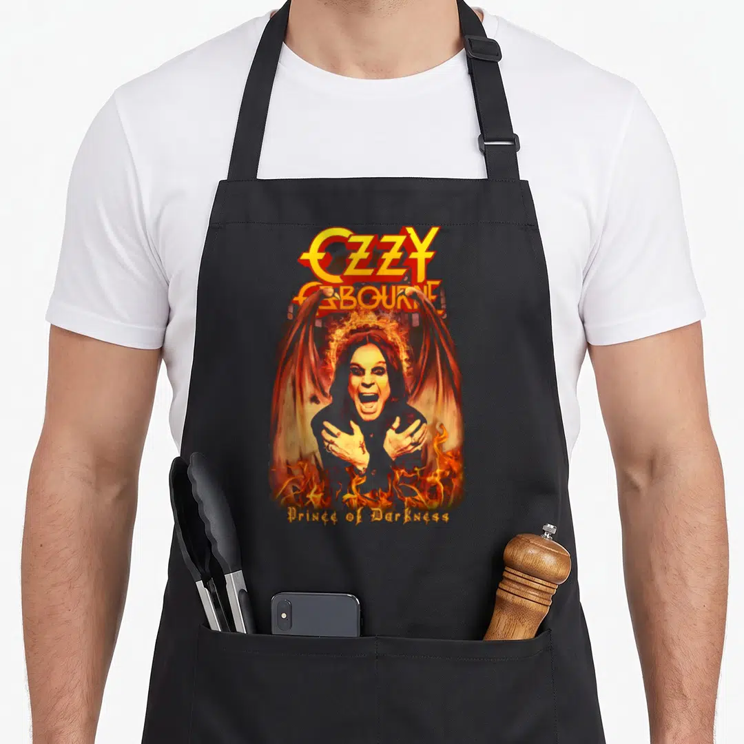 Demon ozzy osbourne apron - Ozzy Osbourne winged portrait with fire and Prince of Darkness text in orange and yellow — shown on a black cotton canvas apron against a white background