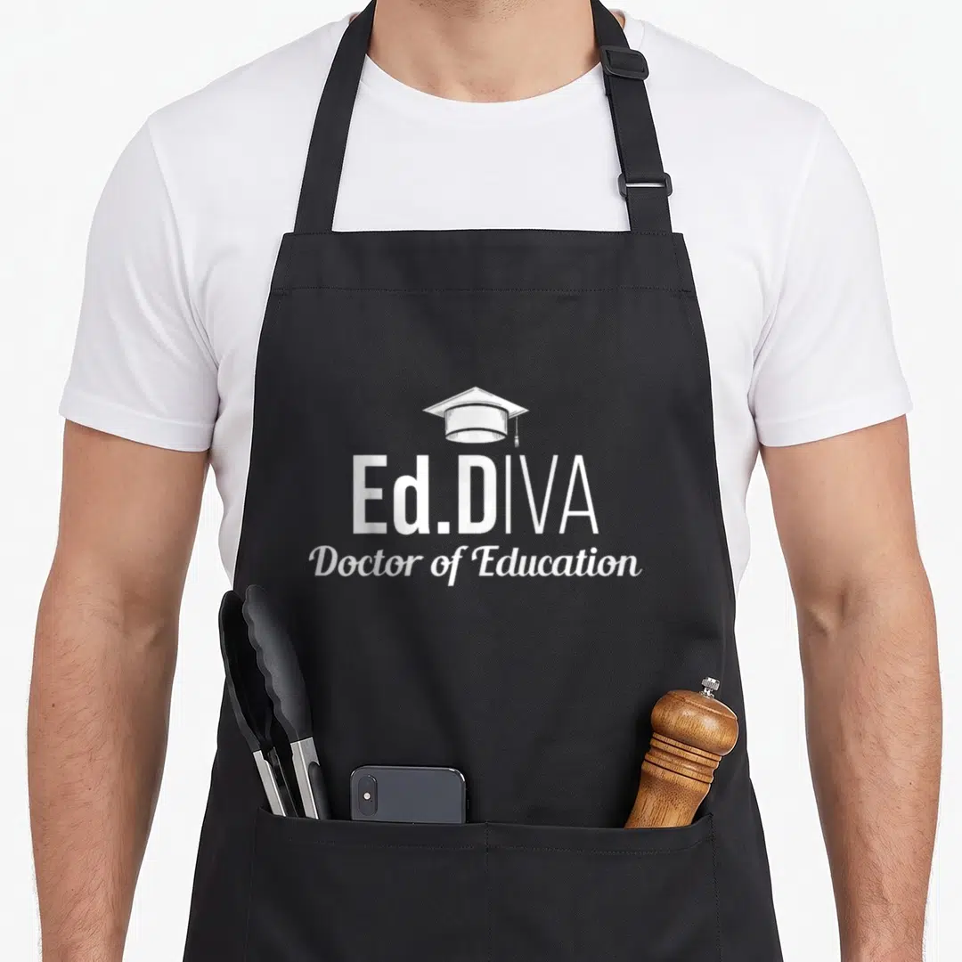 Diva doctor apron - White graduation cap above Ed.DIVA block letters and Doctor of Education script text — shown on a black cotton canvas apron against a white background