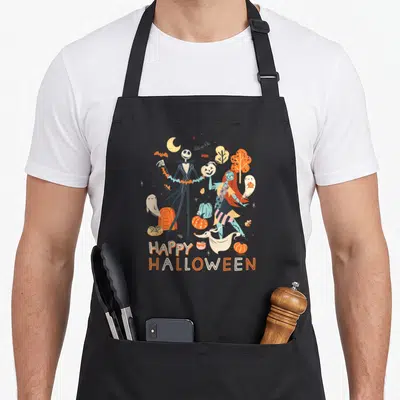 Sally halloween apron - Jack and Sally with ghosts, pumpkins, and stacked HAPPY HALLOWEEN text in cartoon style — shown on a black cotton canvas apron against a white background