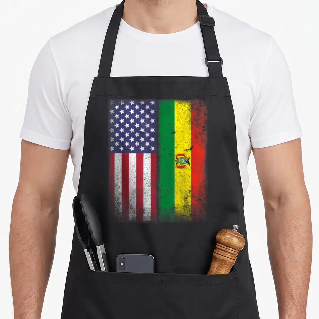 Bolivian american flag apron - Distressed US and Bolivia flags joined side-by-side in blue red white green and yellow — shown on a black cotton canvas apron against a white background