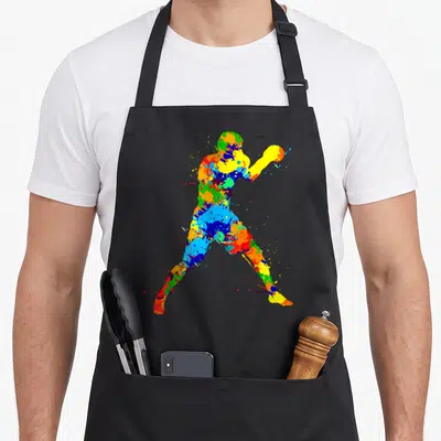 Boxing boxer apron - Multicolored watercolor paint splatter silhouette of an athlete holding a ball — shown on a black cotton canvas apron against a white background