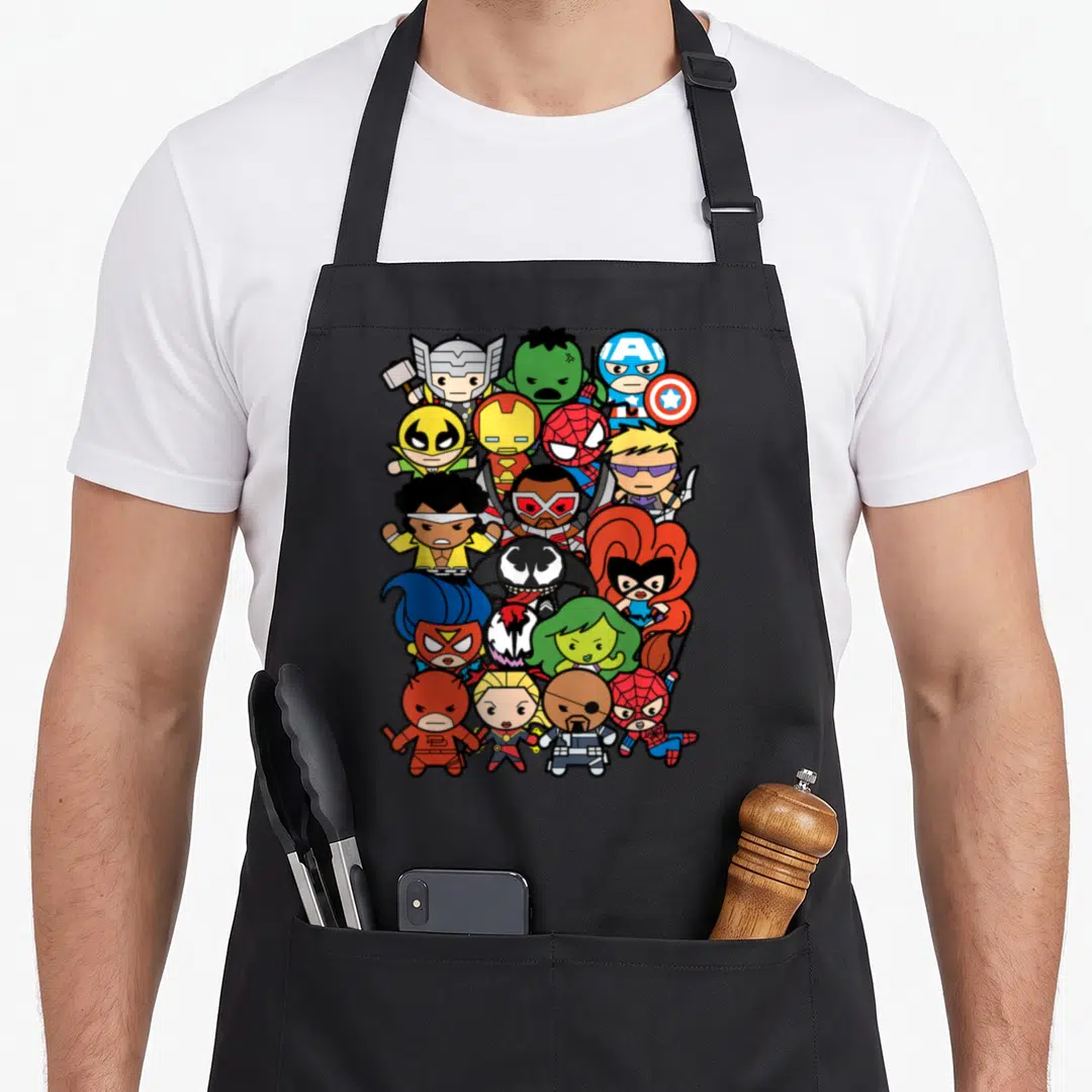 Heroe villain kawaii apron - Chibi superhero cluster in vertical oval with red blue yellow green black cartoon figures — shown on a black cotton canvas apron against a white background