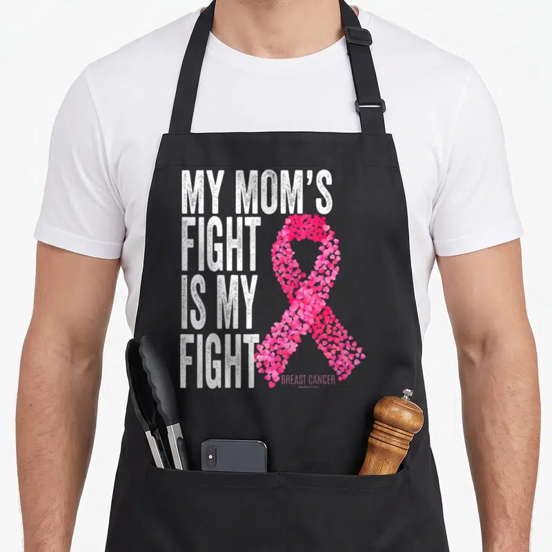 Fight support breast cancer awareness aprons - White text reading My Mom's Fight next to a pink ribbon made of small — shown on a black cotton canvas apron against a white background