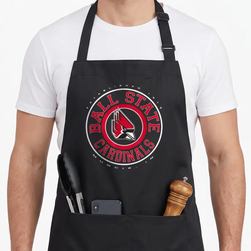 Showtime cardinal apron - Ball State Cardinals logo with cardinal head in red circle and established 1918 text — shown on a black cotton canvas apron against a white background