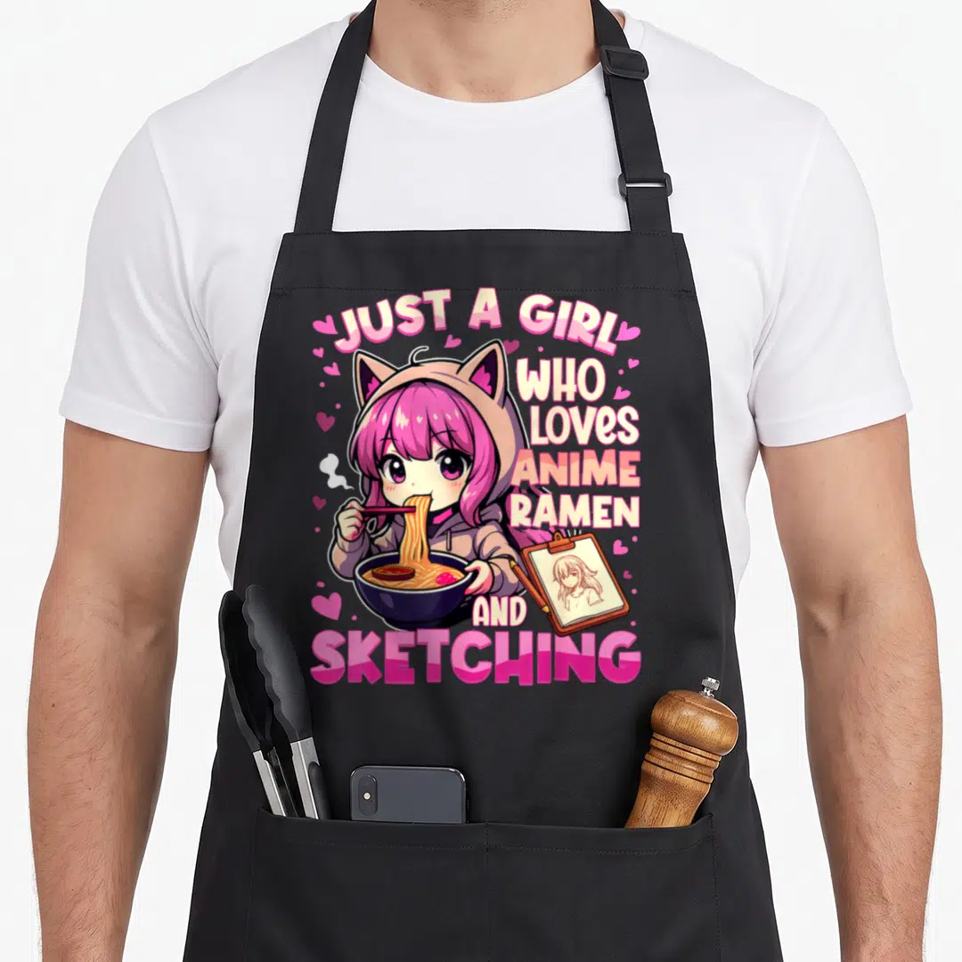 Funny anime japan apron - Girl in cat hoodie eating ramen with sketching text and pink hearts — shown on a black cotton canvas apron against a white background