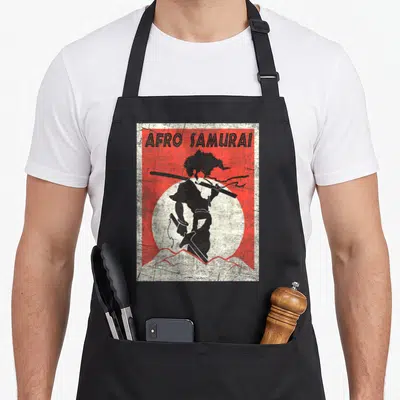 Afro fighter apron - AFRO SAMURAI text above black samurai silhouette with sword against red background and white sun — shown on a black cotton canvas apron against a white background