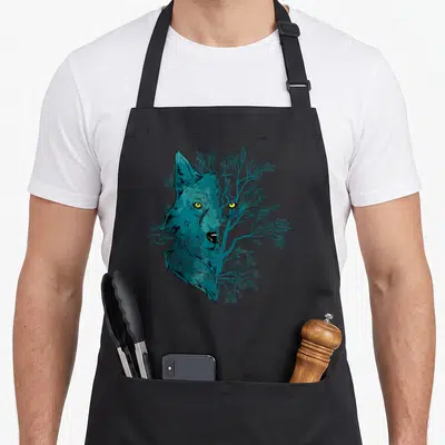 Nature predator apron - Teal wolf head merging into yellow-eyed leafless branches in line art — shown on a black cotton canvas apron against a white background