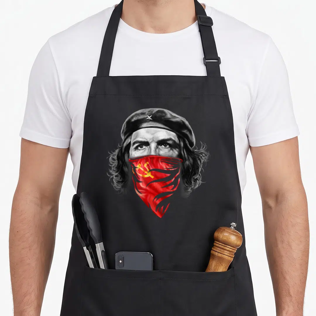 Che bandana apron - Realistic portrait of a man in a black beret with a red bandana featuring a yellow hammer — shown on a black cotton canvas apron against a white background