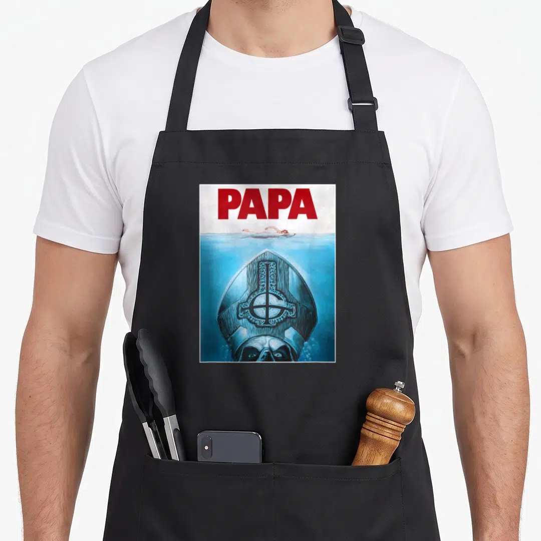 Poster ghost apron - Red PAPA text above blue water with submerged monster wearing a mitre and eyes visible — shown on a black cotton canvas apron against a white background
