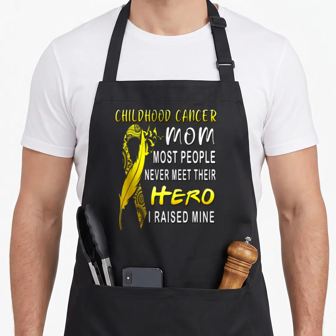 Childhood mom and son aprons - Yellow ribbon feather with text CHILDHOOD CANCER MOM HERO I RAISED MINE — shown on a black cotton canvas apron against a white background