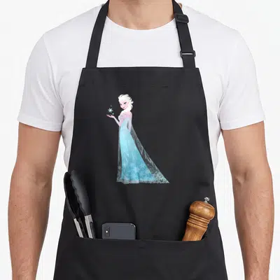 Snowflake magic apron - Elsa standing in light blue holding a snowflake in cartoon style — shown on a black cotton canvas apron against a white background
