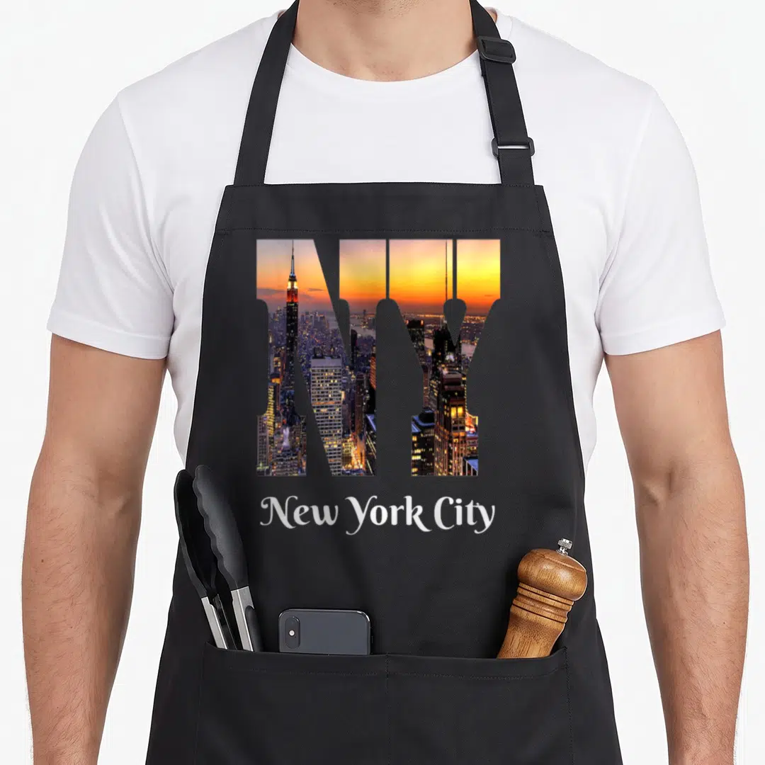 Iconic new york apron - NY letters filled with skyline photo and New York City text below — shown on a black cotton canvas apron against a white background