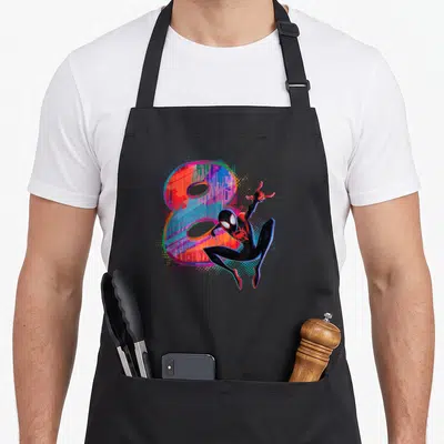 Morale 8th birthday apron - Miles Morales Spider-Man posing in front of a multicolored number 8 with halftone dots — shown on a black cotton canvas apron against a white background