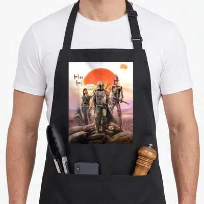 Poster horse dad apron - Mandalorian, Cara Dune, IG-11, Grogu, TIE fighters, orange sun, desert rocks — shown on a black cotton canvas apron against a white background