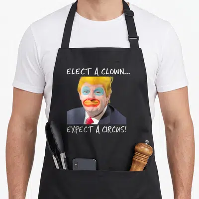 Elect expect clown aprons - Donald Trump with clown makeup and text Elect A Clown Expect A Circus — shown on a black cotton canvas apron against a white background
