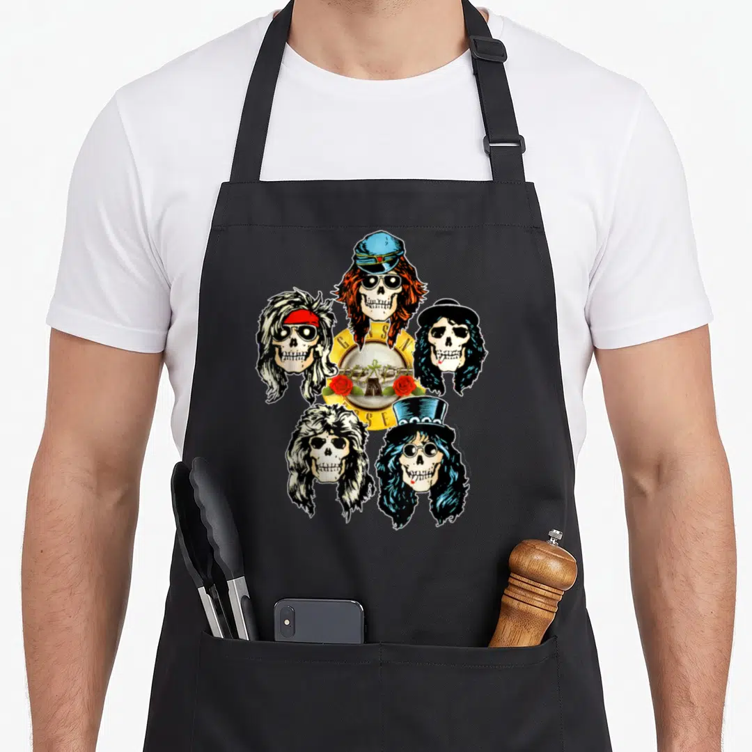 Skull gun apron - Five cartoon skulls with hats surrounding yellow disc with G,A,S,N,R,O,S,E letters and red roses — shown on a black cotton canvas apron against a white background