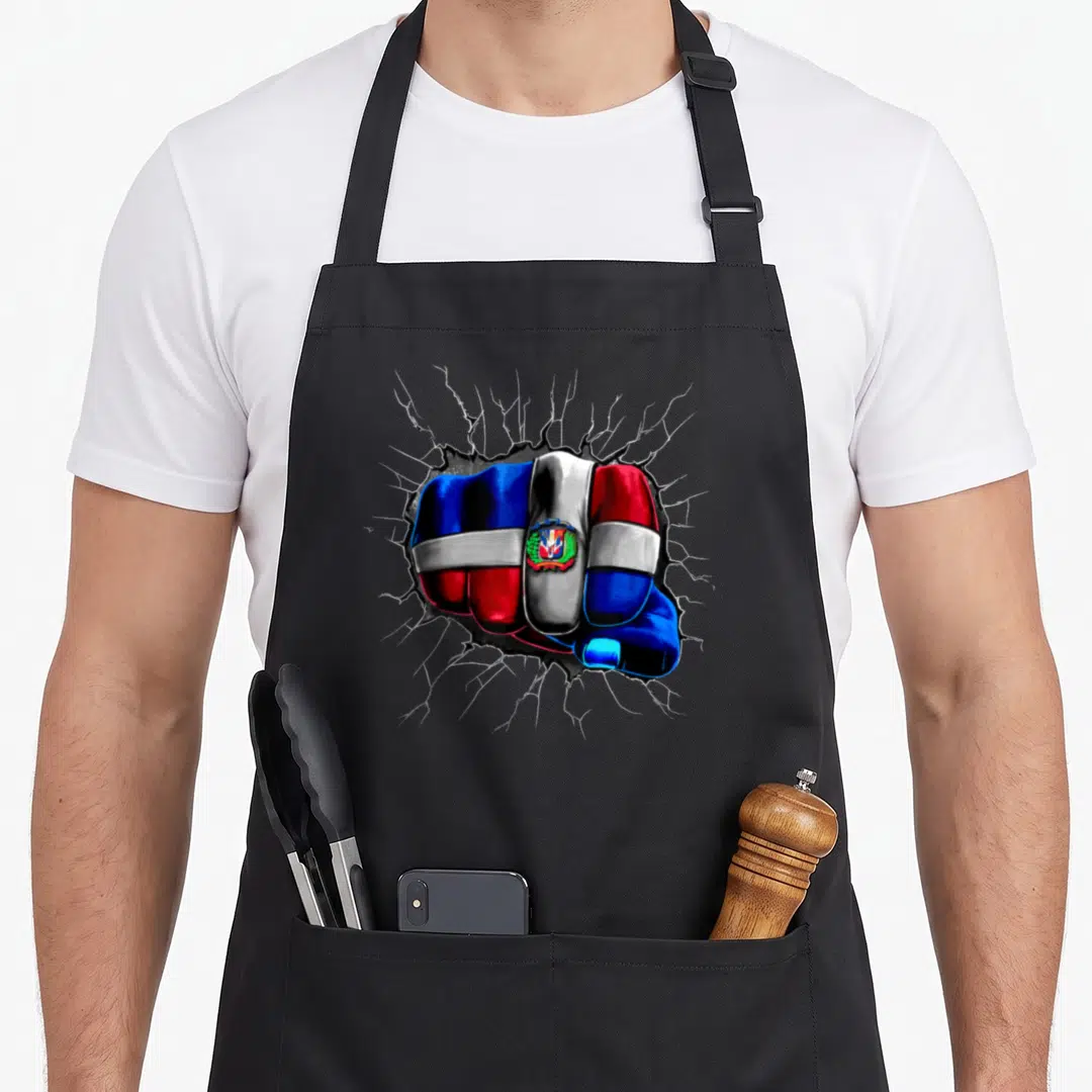 Flag dominican republic apron - Fist painted in blue red and white flag cracking through grey surface — shown on a black cotton canvas apron against a white background