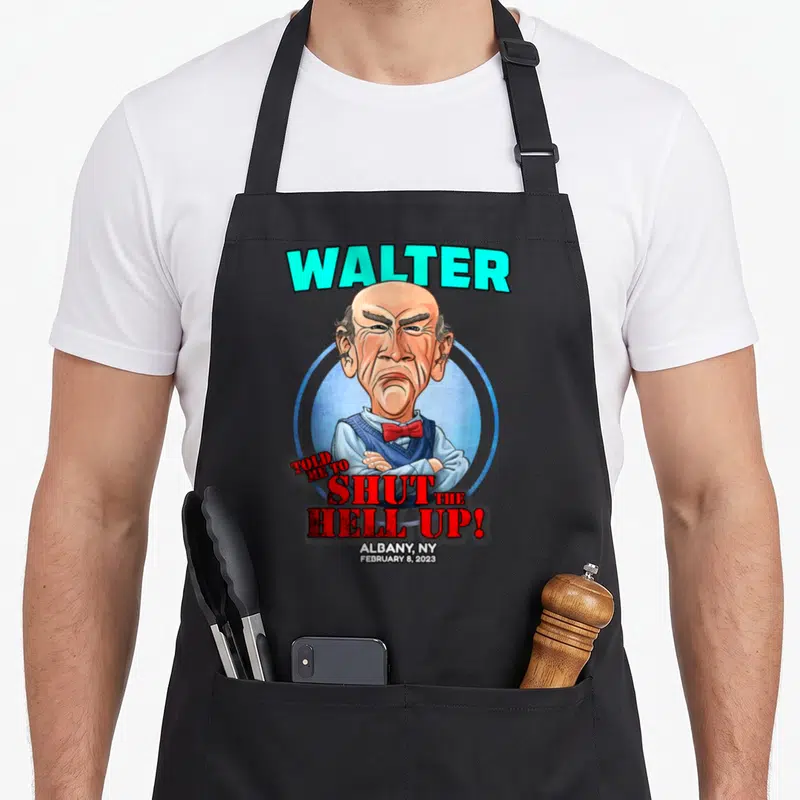 Walter albany apron - Caricature of a man with arms crossed surrounded by red text WALTER TOLD ME TO SHUT THE HELL UP — shown on a black cotton canvas apron against a white background