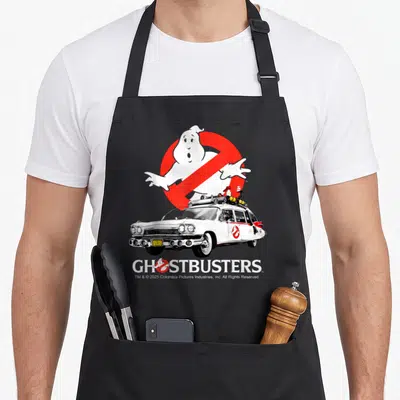 Ecto halloween apron - Ecto-1 car and GHOSTBUSTERS text with no-ghost symbol in white, red, and black — shown on a black cotton canvas apron against a white background