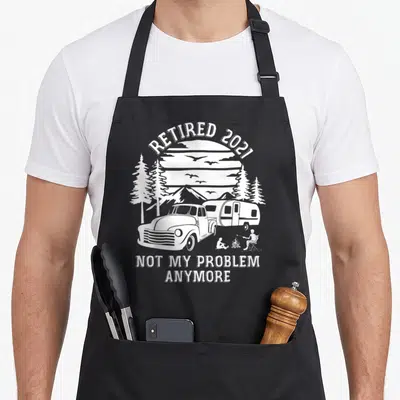 Problem camping apron - White line art of truck camper campfire with retired 2021 text — shown on a black cotton canvas apron against a white background