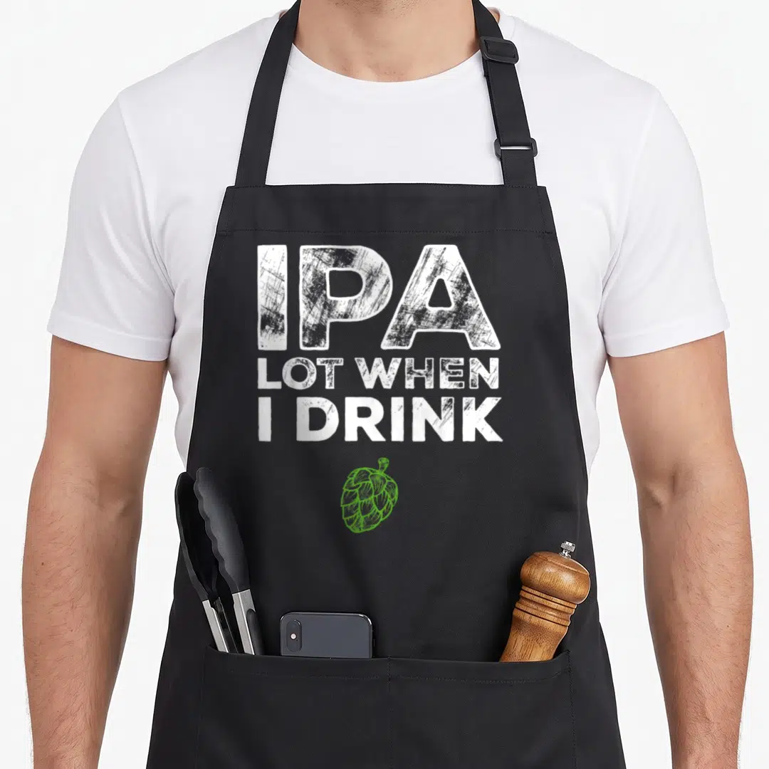 Ipa lot of aprons - Distressed white text reading IPA Lot When I Drink above a green hop illustration — shown on a black cotton canvas apron against a white background