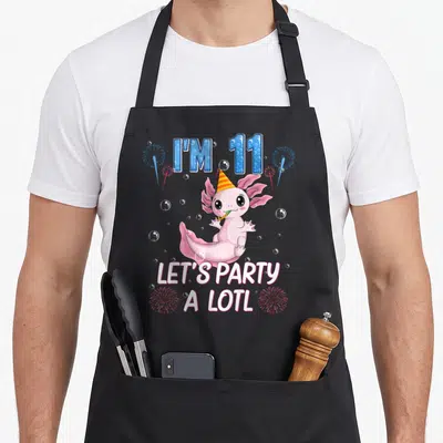 Axolotl 11th birthday apron - Pink axolotl with party hat blowing blower surrounded by blue text I'M 11 and white text — shown on a black cotton canvas apron against a white background