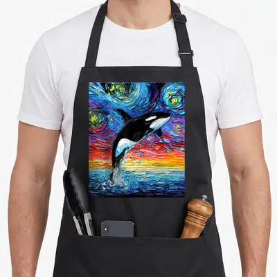 Orca colorful aprons - Black orca leaping from blue water into swirling starry sky with yellow and red strokes — shown on a black cotton canvas apron against a white background