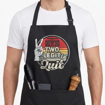 Birthday hip aprons - Retro circle with boombox, peace sign hand, and striped background — shown on a black cotton canvas apron against a white background