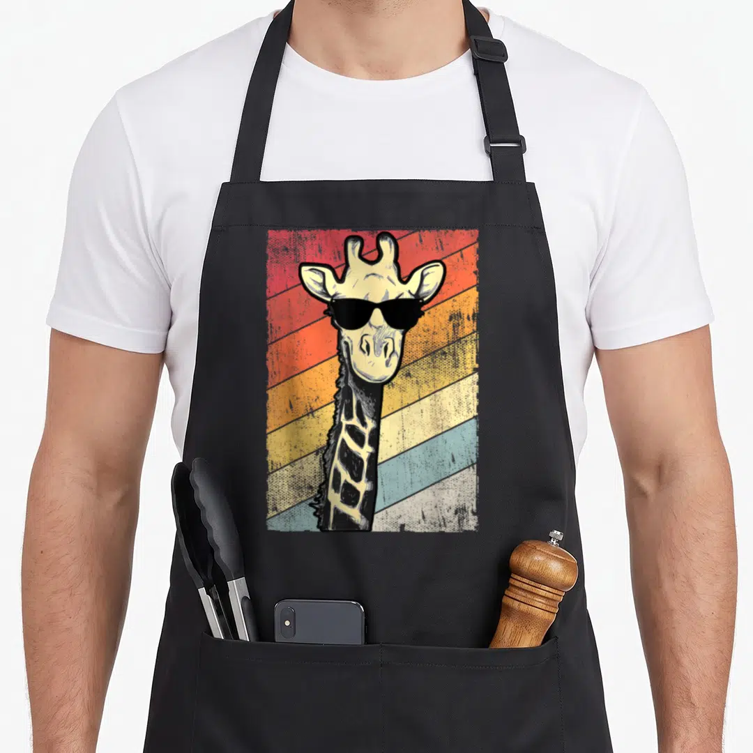 Sunglass giraffe apron - Retro giraffe wearing sunglasses on diagonal red orange yellow stripes — shown on a black cotton canvas apron against a white background